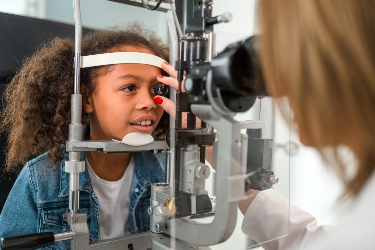 Little Black Child Having her Right Eye Checked by Professional Eye Doctor