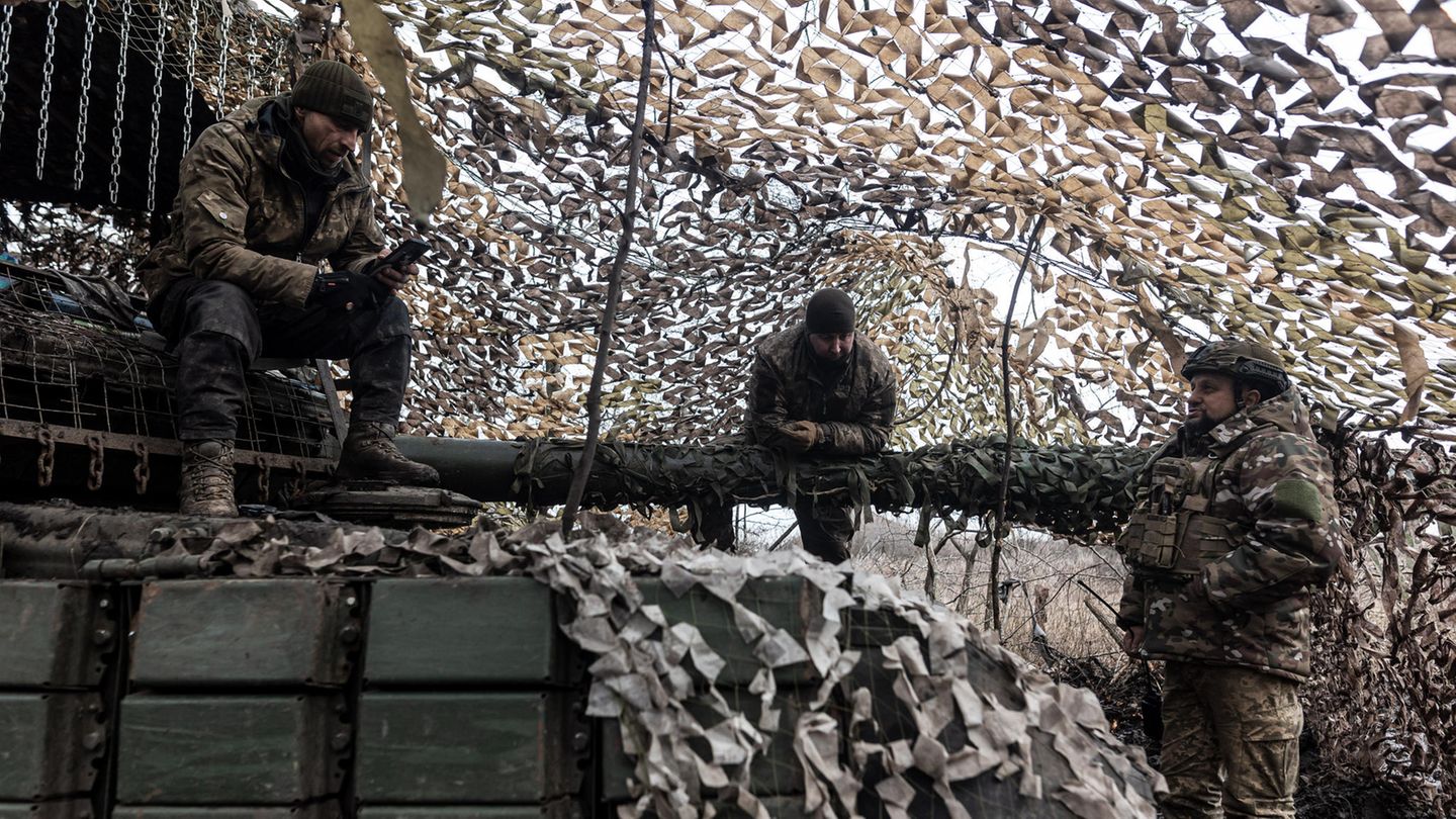 Verteidigung: Ukrainische Soldaten unterhalten sich, während einer sich auf das Geschütz eines Panzers stützt